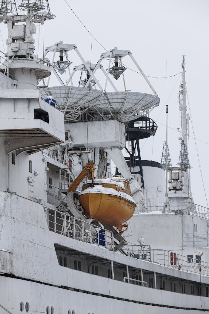 Home A historic ship with satellite dishes and lifeboat in snowy Kaliningrad, Russia.